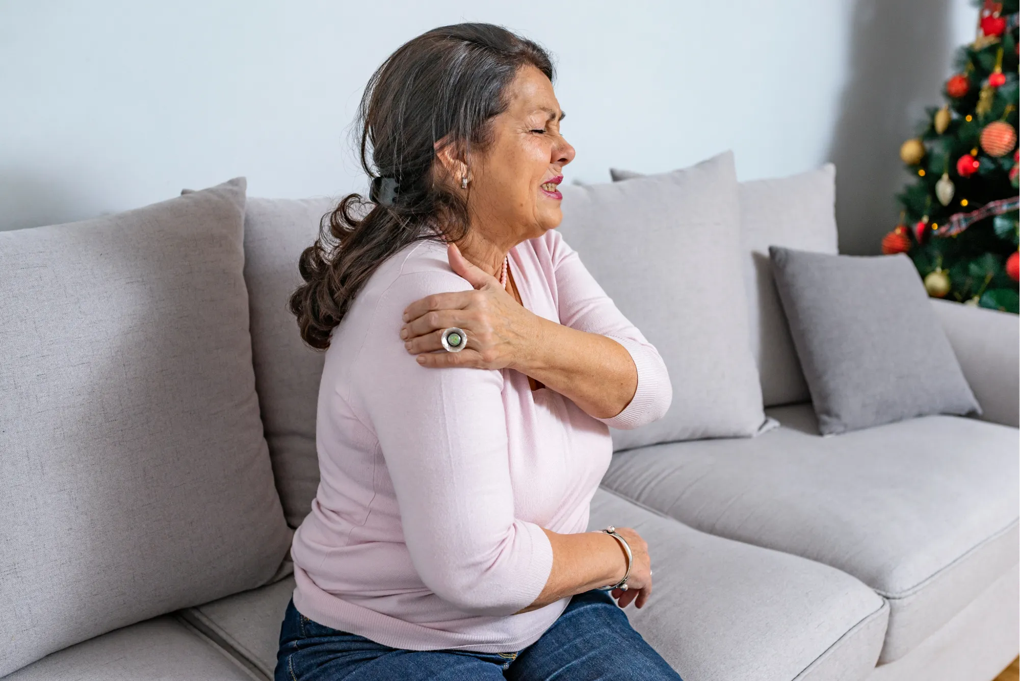 A female patient feeling the symptoms of shoulder stiffness and exploring treatment options with her doctor.