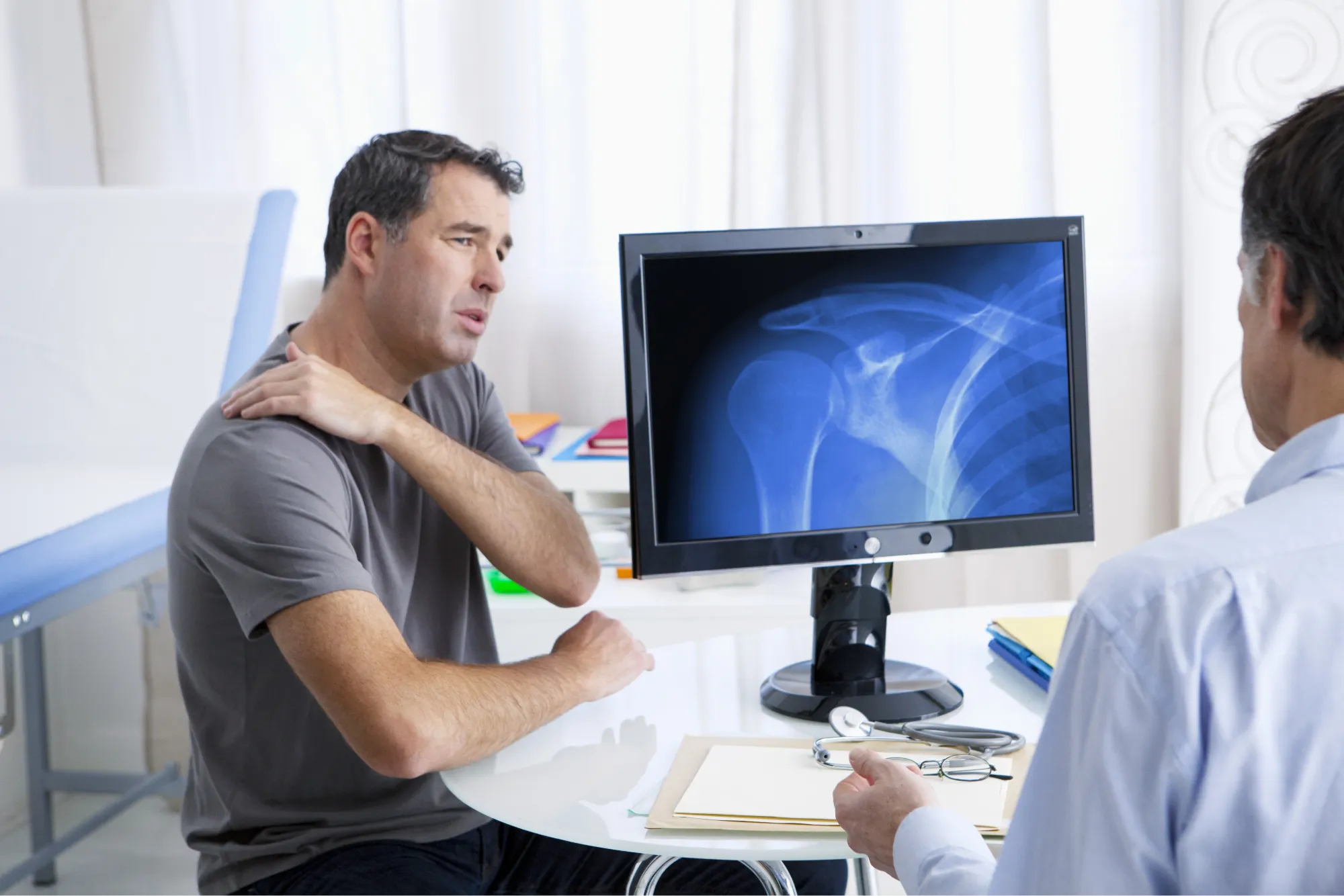 Patient getting his shoulder checked by an orthopedic doctor