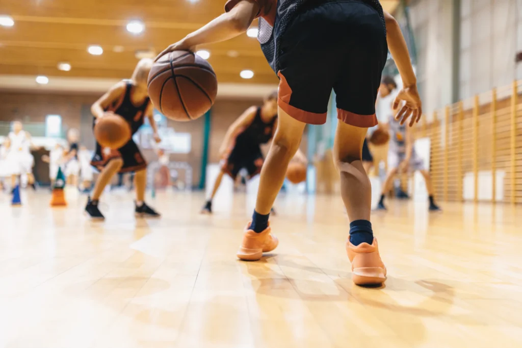 Young kid playing basketball with knee problems