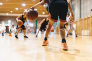 Young kid playing basketball with knee problems